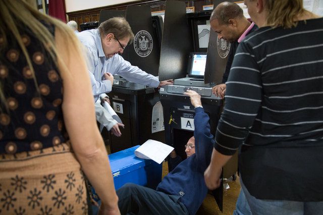 BOE workers try and fix a broken scanner on Election Day 2018
